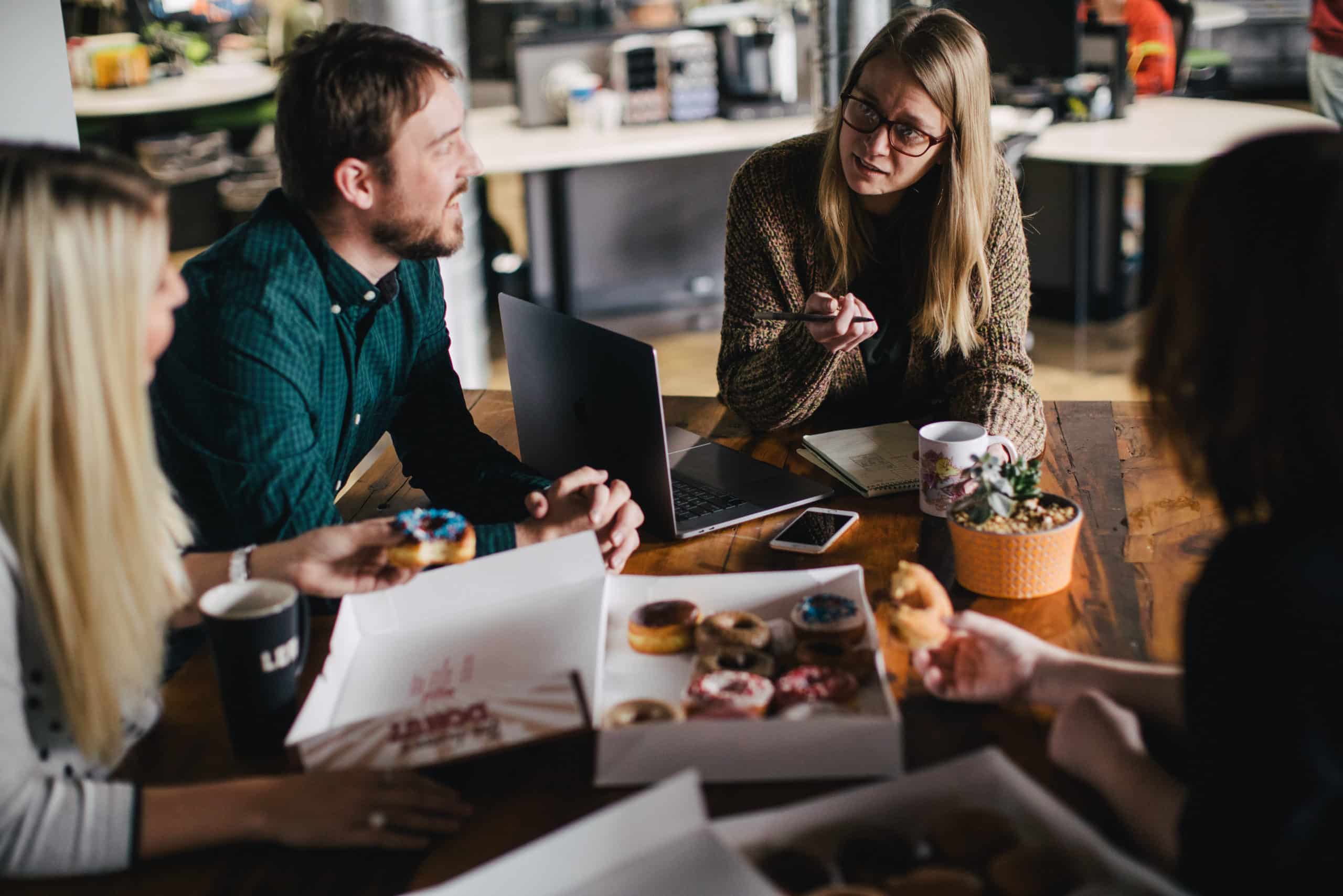 People working at a table with donuts